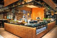 een chef-kok die achter een balie in een restaurant staat bij InterContinental Phuket Resort by IHG in Kamala Beach