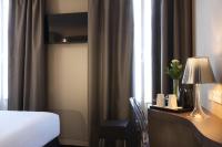 a hotel room with a bed and a desk with a lamp at Best Western Quartier Latin Pantheon in Paris