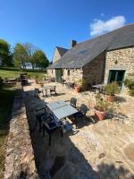 eine Terrasse mit Tischen und Stühlen vor einem Gebäude in der Unterkunft Manoir De Rigourdaine in Plouër-sur-Rance