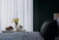 a table with a plate of food and a vase of flowers at Original Boutique Hotel in Tbilisi City