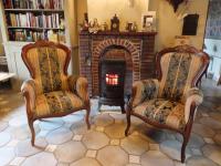 two chairs in a living room with a fireplace at La Quitapenas in Ronse