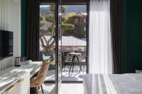 a room with a bed and a balcony with a table at Original Boutique Hotel in Tbilisi City