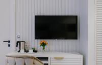 a living room with a tv on a white wall at Original Boutique Hotel in Tbilisi City