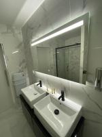 a white bathroom with a sink and a mirror at Lh Rooms Location in Le Havre