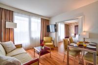 a living room with a couch and a table at Zenitude Relais &amp; Spa - Paris Charles de Gaulle in Roissy-en-France