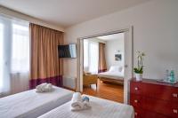 a hotel room with two beds and a mirror at Zenitude Relais &amp; Spa - Paris Charles de Gaulle in Roissy-en-France