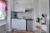 a small kitchen with white cabinets and a sink at Appartement 2 pièces plein de charmes - Caroline in Valentigney