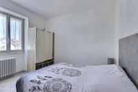 a bedroom with a bed with a white bedspread and a window at Appartement 2 pièces plein de charmes - Caroline in Valentigney