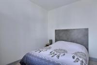 a bedroom with a white bed with a gray headboard at Appartement 2 pièces plein de charmes - Caroline in Valentigney