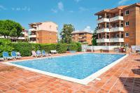 Una piscina con dos sillas y un edificio. en Pierre &amp; Vacances Comarruga, en Comarruga