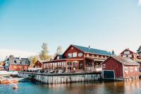 ein Gebäude am Wasser neben einem Yachthafen in der Unterkunft Skatans Café & Krog in Skatan