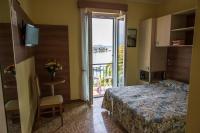 a hotel room with a bed and a door with a balcony at Hotel Villa Ruscello in Baveno