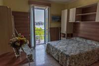 a bedroom with a bed and a vase of flowers on a table at Hotel Villa Ruscello in Baveno