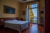 a bedroom with a bed and a large window at Hotel Villa Ruscello in Baveno