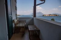 a balcony with two chairs and a table and a view of the water at Hotel Villa Ruscello in Baveno