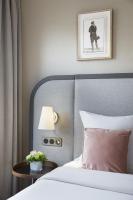 a bedroom with a bed and a table with a lamp at Warwick Reine Astrid - Lyon in Lyon