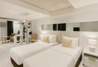 two beds in a white room with a living room at Original Boutique Hotel in Tbilisi City