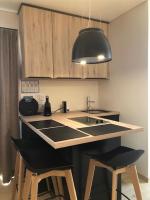 a kitchen with a sink and two bar stools at Vakantiehuis Onverbloemd in Tielt