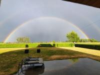 a rainbow in the sky over a yard with a pool at Vakantiehuis Onverbloemd in Tielt