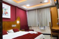 Habitación de hotel con cama y paredes rojas en Capri Hotel, en Duque de Caxias
