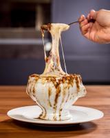 a person is holding a spoon with a dessert on a plate at Pendry Chicago in Chicago