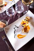 ein weißer Teller mit Essen auf einem Tisch mit Weingläsern in der Unterkunft Castel Damandre - Demeures & Châteaux in Arbois