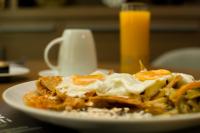 a plate of food with eggs and fries on a table at KALI Centro Mexico City in Mexico City
