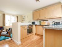 a kitchen with wooden cabinets and a counter top at Pugwash Cottage in Falmouth