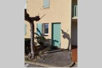 a shadow of a tree on the side of a building at Appartement avec jardin Gruissan in Gruissan