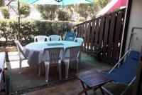 a table and chairs on a patio with an umbrella at Appartement avec jardin Gruissan in Gruissan