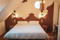 a bedroom with a white bed with a brick wall at Le Saltimbanque - Auberge du Moulin in Eaucourt-sur-Somme