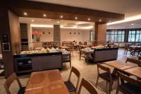 um restaurante com mesas e cadeiras e um bufê em Intercity Portofino Florianópolis em Florianópolis