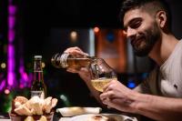 Un uomo sta tenendo un bicchiere di vino di Hotel Termal Emperatriz Termas de Río Hondo a Termas de Río Hondo