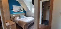 a small bedroom with a bed and a blue wall at The Originals City, Hôtel Les Océanes, Lorient in Lorient