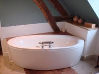 a bathroom with a bath tub in a attic at Moulin de Giboudet Chambres d&#39;hôtes in Bazainville