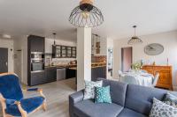 a living room with a blue couch and a kitchen at Les Abîmes, beau logement avec 2 chambres avec parking in Saint Malo