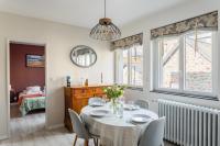 a dining room with a table and chairs and a bedroom at Les Abîmes, beau logement avec 2 chambres avec parking in Saint Malo