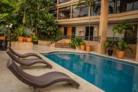 Una piscina con dos sillas al lado de un edificio. en Hotel San Luis Lindavista, en Culiacán
