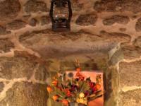 a light hanging from a stone wall with a vase of fruit at Gîte Essertines-en-Châtelneuf, 3 pièces, 6 personnes - FR-1-496-16 in Essertines-en-Châtelneuf