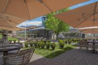 un patio al aire libre con mesas y sombrillas en Château Brachet, en Grésy-sur-Aix