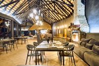 a restaurant with tables and chairs and a fireplace at Ai Aiba - The Rock Painting Lodge in Omaruru