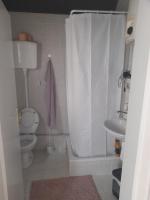 a bathroom with a toilet and a shower curtain at Wanted Šabac apartman in Šabac