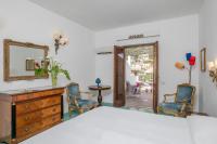 a bedroom with a dresser and two chairs and a mirror at Hotel Poseidon in Positano
