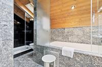 a bathroom with a shower and a tub and a toilet at Grand Hotel Zermatterhof in Zermatt