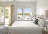 ein weißes Schlafzimmer mit einem großen Bett und einem Fenster in der Unterkunft Parrot Key Hotel &amp; Villas in Key West