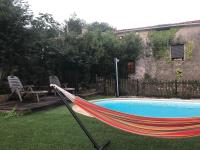 a hammock in a yard next to a pool at Gîte Tanagra : Maison avec piscine et vue exceptionnelle in Roquefort-les-Cascades