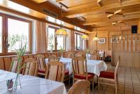 a restaurant with white tables and chairs and windows at Gasthof Hotel Schermer in Bad Häring