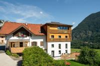 a house with a wooden roof on top of it at Schneggnheisl - Appartement in Sautens