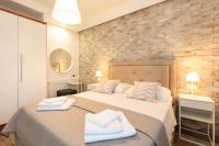 a bedroom with two beds and a brick wall at Ela in Rijeka