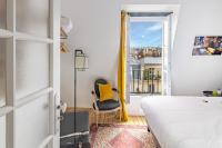 a bedroom with a bed and a chair and a window at MaisondesChaumes-Paris in Paris